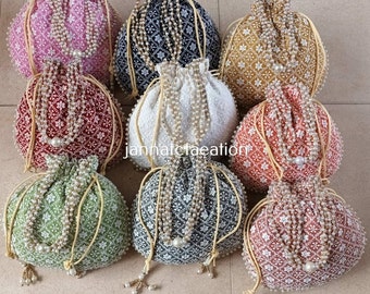 Può includere: Assortimento di nove borse a cordoncino con decorazioni di perle. Le borse sono realizzate in tessuto e sono disponibili in vari colori, tra cui rosa, nero, bianco, oro, rosso, verde e grigio.