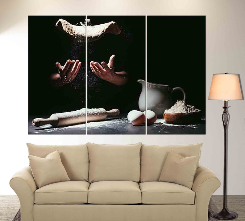May include: A split canvas print of a dark background with a chef tossing dough in the air, a rolling pin, two eggs, a pitcher, and a bowl of flour.