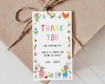 Könnte beinhalten: Ein weißes Dankeschön-Etikett mit einem bunten Rand aus Blumen, Hasen, Küken und Eiern. Der Text lautet "Danke für's Hüpfen! Hier ist ein Leckerli für deine Freundlichkeit. Liebe, Jamie."