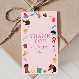 May include: Pink thank you tag with a horse theme. The tag is decorated with horse-related icons, including a horseshoe, a saddle, a riding crop, and a bucket. The text on the tag reads "THANK YOU for galloping by SARAH".