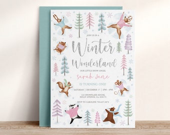 Op de afbeelding: Een winterwonderland-thema verjaardagsuitnodiging met een roze en blauwe kleurstelling. De uitnodiging toont verschillende bosdieren die truien dragen en sneeuwvlokken. De tekst op de uitnodiging luidt: "Doe mee met ons in een Winterwonderland, Onze kleine sneeuwengel Sarah Jane wordt één jaar!"