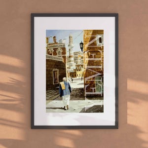 Puede incluir: Una pintura de una calle estrecha en una ciudad de Oriente Medio. La calle está bordeada de edificios altos con puertas y ventanas arqueadas. Un hombre con una túnica blanca y una camisa azul camina por la calle. Los edificios están pintados en colores cálidos, incluyendo amarillo, naranja y marrón.