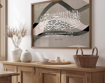 May include: A rectangular wall art piece in a wooden frame featuring white Arabic calligraphy and the English text: Oh my Lord, I am in desperate need of whatever you send down upon me, Quran 28:24, set against a background of abstract beige and black waves.