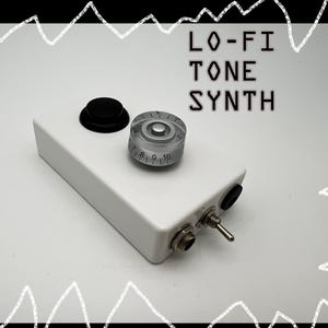 May include: A white electronic device labeled "LO-FI TONE SYNTH" with a black knob, a silver dial, and a toggle switch. The silver dial has numbers from 7 to 10. The device has a rectangular shape.