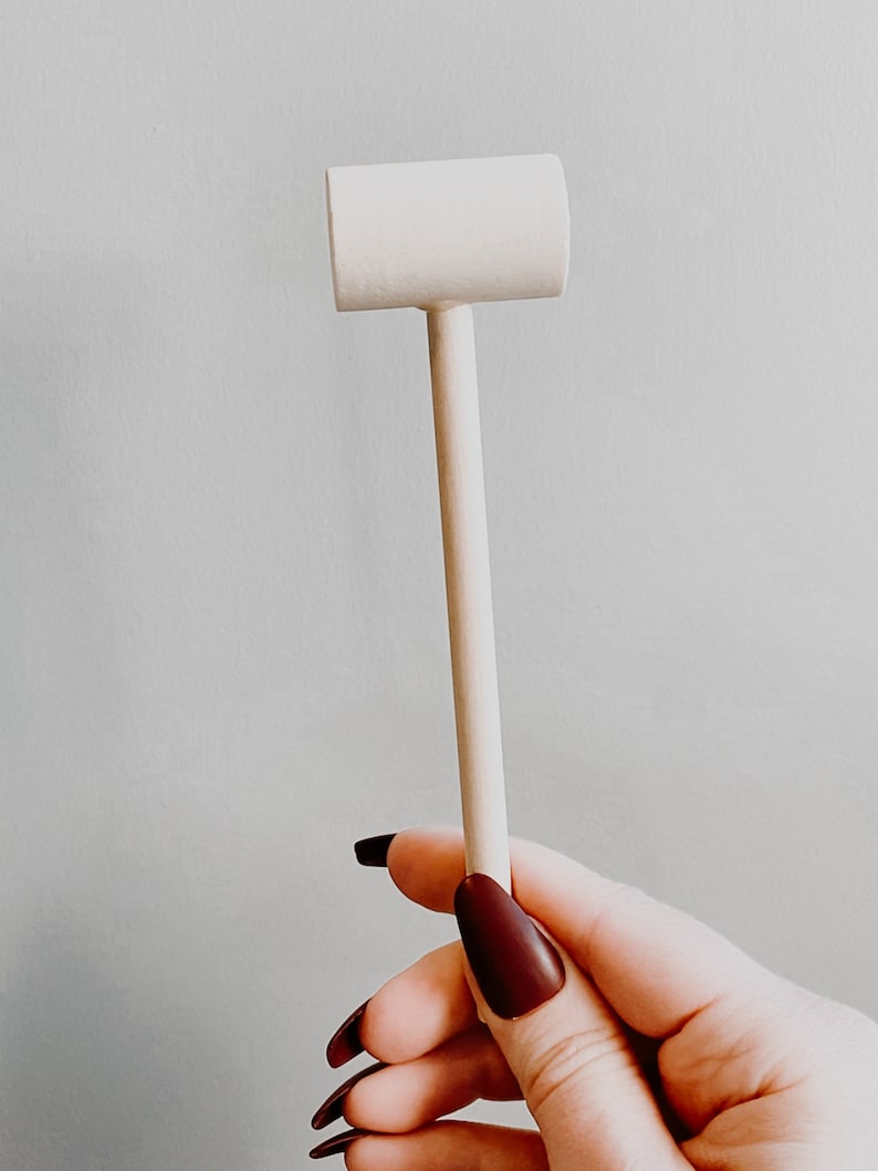 K&ouml;nnte beinhalten: Ein wei&szlig;er Holzhammer mit einem abgerundeten Kopf und einem langen, schlanken Stiel.