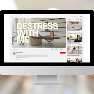 Puede incluir: Un monitor de ordenador muestra una p&aacute;gina web con el texto "DESTRESS WITH ME". La p&aacute;gina web presenta un entorno de oficina moderno con un escritorio y una silla. Varias miniaturas de v&iacute;deo son visibles a la derecha.