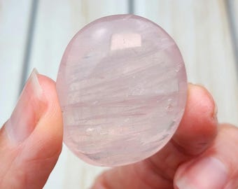 Può includere: Una pietra di palma in quarzo rosa pallido con una superficie liscia e lucida e striature visibili.