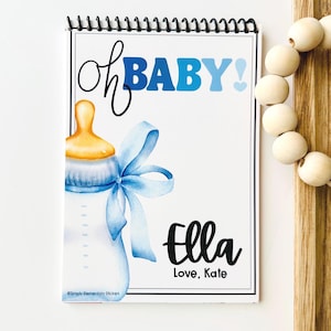 May include: A spiral-bound notepad with a baby shower theme. The cover features a watercolor illustration of a baby bottle with a blue bow, the words "Oh BABY!" in blue, and the name "Ella" with "Love, Kate".