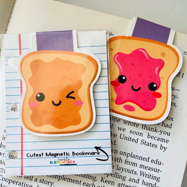 May include: Two cute magnetic bookmarks shaped like toast with happy faces. One has a pink jelly spread and the other has a yellow spread. The text "Cutest Magnetic Bookmark" and "Simply Elementary" is printed on the bottom of the bookmarks.