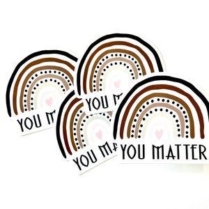 May include: Four rainbow stickers with the text "You Matter" in black lettering. The rainbows are made up of brown, beige, and white stripes with black dots. Each rainbow has a small pink heart in the center.