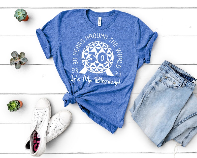 May include: A blue t-shirt with a white graphic of the Epcot Spaceship Earth with the text "30 Years Around The World 93 30 23 It's My Birthday!"