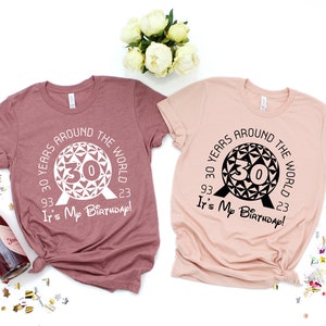 May include: Two t-shirts with a graphic of the Spaceship Earth ride at Epcot. The text on the shirts reads "30 Years Around the World 93' 23' It's My Birthday!"