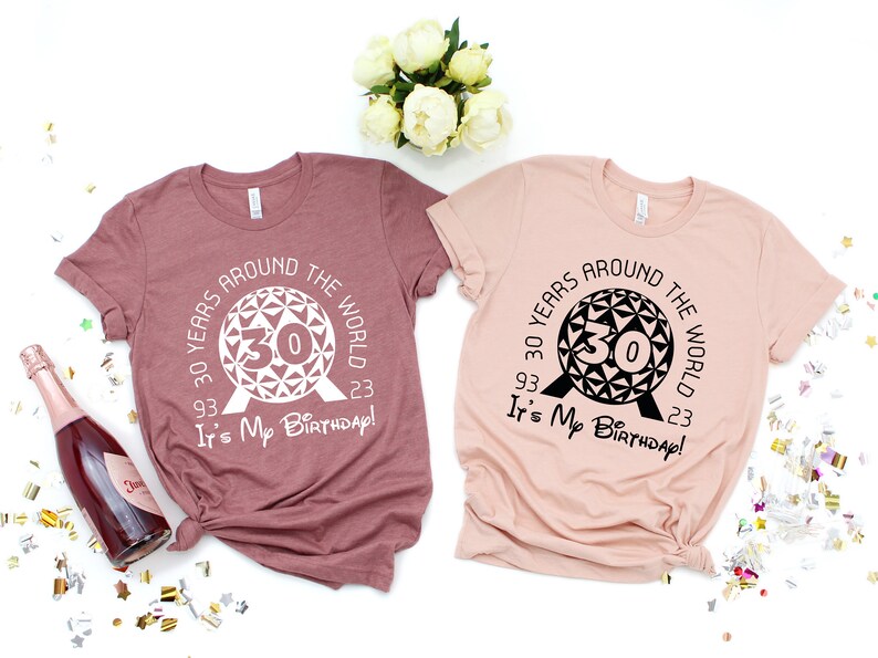 May include: Two t-shirts with a graphic of the Spaceship Earth ride at Epcot. The text on the shirts reads "30 Years Around the World 93' 23' It's My Birthday!"