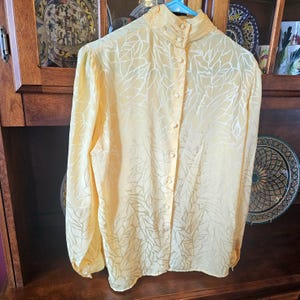 Blusa de seda vintage de los años 80 para mujer, color amarillo plátano, cuello alto simulado y abotonada.