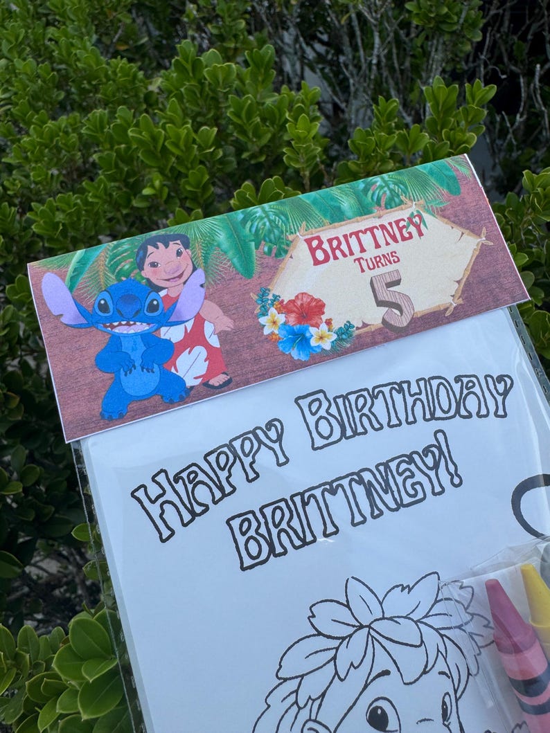 May include: A clear plastic bag containing a coloring book and crayons. The coloring book has the words "Happy Birthday Brittney!" printed on it. The top of the bag has a decorative banner with the words "Brittney Turns 5" and images of Stitch and Lilo.