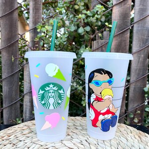 May include: Two clear plastic reusable cups with lids and straws. One cup has a design of a cartoon character with a yellow ice cream cone. The other cup has a design of ice cream cones and the Starbucks logo.