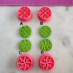 May include: Four pink and green plastic cookie cutters with a starburst design. The cutters are labeled A, B, C, and D.
