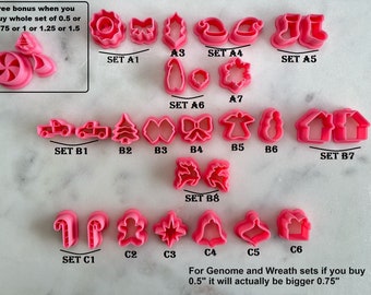 May include: A set of pink plastic cookie cutters in various Christmas shapes, including a Christmas tree, a house, a reindeer, a bell, a candy cane, a gingerbread man, and a star. The cutters are arranged in rows on a white marble surface. Free bonus when you buy a whole set of 0.5 or 0.75 or 1 or 1.25 or 1.5.