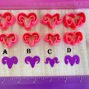 May include: Eight pink plastic ram cookie cutters and six purple fondant ram shapes. The cookie cutters are labeled A, B, C, and D.
