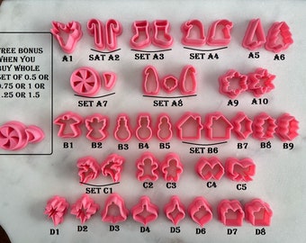 May include: A set of pink plastic Christmas cookie cutters. The cutters are arranged in rows and labelled with letters and numbers. The text "FREE BONUS WHEN YOU BUY WHOLE SET OF 0.5 OR 0.75 OR 1 OR 1.25 OR 1.5" is visible in the image.