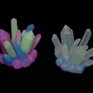 May include: Two clusters of colorful crystal-shaped soap. The cluster on the left is pink, green, and blue. The cluster on the right is light blue and white.
