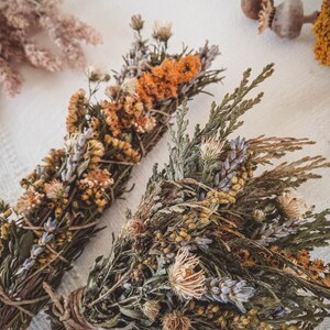 May include: Two bundles of dried herbs and flowers tied with twine. The bundles are made with lavender, cedar, and other dried botanicals.