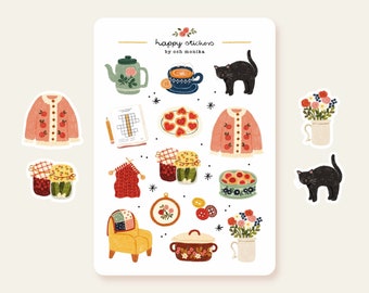 May include: A sheet of stickers featuring illustrations of a teapot, a cup of tea, a cat, a sweater, a jar of jam, a bowl of fruit, a chair, a pot, and flowers. The stickers are designed in a whimsical style with bright colors and patterns. The text "happy stickers by ooh monika" is printed at the top of the sheet.