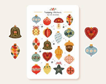 Puede incluir: Una hoja de pegatinas de temática navideña de colores con adornos, campanas, bellotas y un corazón. Las pegatinas están ilustradas en un estilo caprichoso con un aspecto pintado a mano. El texto "happy stickers by ooh monika" está impreso en la parte superior de la hoja.