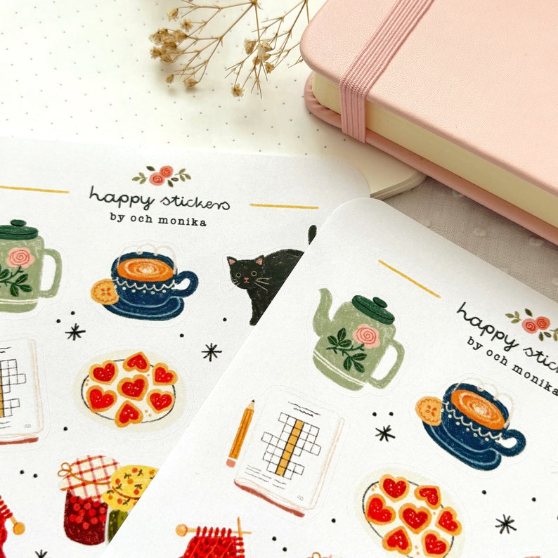 Op de afbeelding: Een vel stickers met verschillende ontwerpen, waaronder een theepot, een kopje thee, een kat, een bord koekjes, een kruiswoordpuzzel en een breinaald. De stickers zijn allemaal met de hand getekend en hebben een speelse, vintage stijl. De tekst op de stickers luidt "happy stickers by ooh monika".