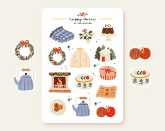 Op de afbeelding: Een vel stickers met een winterthema. De stickers bevatten illustraties van een theepot, een open haard, een krans, een huis, een cadeaudoos, een bol wol, een bord met koekjes, een trui, een kom met pudding, een deken en mistletoe.
