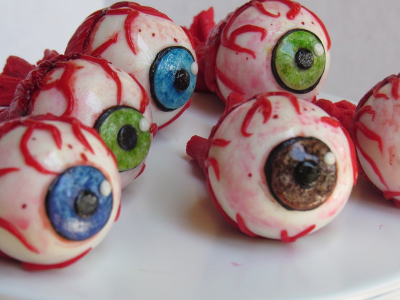 K&ouml;nnte beinhalten: F&uuml;nf realistisch aussehende Augenbonbon-Dekorationen mit roten Adern, wei&szlig;er Sklera und unterschiedlichfarbigen Iris. Die Augen sind aus Fondant und perfekt f&uuml;r Halloween-Partys oder gruselige Dekorationen.