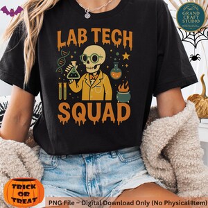 May include: Black t-shirt with a Halloween-themed graphic. The design features a skeleton in a lab coat and glasses, holding a beaker. The text "LAB TECH SQUAD" is in orange, with additional science-related illustrations.