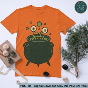 Puede incluir: Camiseta naranja con un diseño de caldero de dibujos animados y monstruo. El monstruo tiene ojos grandes y amarillos y tentáculos verdes. El texto "PNG File - Digital Download Only (No Physical Item)" está en la parte inferior.