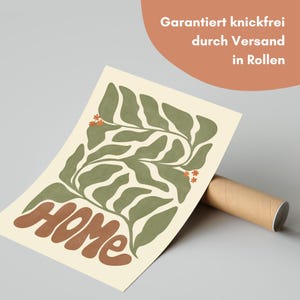 Puede incluir: Un p&oacute;ster beige con un dise&ntilde;o de hojas verdes y la palabra "HOME" en marr&oacute;n. El p&oacute;ster est&aacute; enrollado y listo para enviar. El texto en la parte superior dice "Garantizado sin arrugas mediante env&iacute;o en rollos."