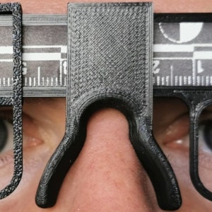 May include: Three black plastic measuring tools with a ruler and a scale. The tools are designed to measure the distance between the eyes, the width of the nose, and the width of the face.