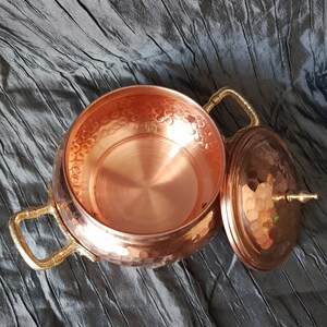 Puede incluir: Un bol de servir de cobre martillado con dos asas de lat&oacute;n y una tapa a juego. El bol tiene un interior brillante y pulido.