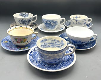 Juego de seis tazas y platillos vintage de colores azul y blanco, diferentes entre sí.