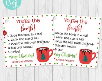 May include: Two square Christmas-themed gift tags with the text "You're the bomb!" in red script. Each tag includes instructions for making hot chocolate, a red mug graphic, and the words "Merry Christmas!"