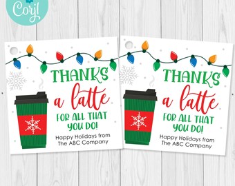Può includere: Due etichette regalo bianche con la scritta "Grazie per tutto quello che fai!" in verde e rosso. Ogni etichetta presenta una tazza di caffè verde con un disegno a fiocco di neve e una stringa di luci colorate.