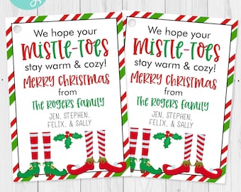 May include: Two Christmas gift tags with a white background, red and green striped border, and the text "We hope your Mistle-Toes stay warm & cozy! Merry Christmas from The Rogers Family." Elf legs and shoes are at the bottom.