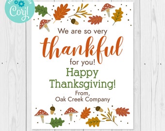 Könnte beinhalten: Eine weiße rechteckige Karte mit herbstlichen Illustrationen und Text. Die Karte zeigt orange, braune und grüne Blätter, Pilze und Eicheln. Der Text lautet "We are so very thankful for you! Happy Thanksgiving!" und "From, Oak Creek Company."