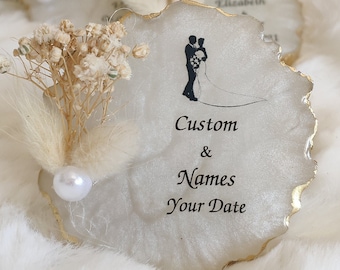 May include: White agate coaster with gold trim, featuring a silhouette of a couple, dried flowers, and the text "Custom & Names Your Date".