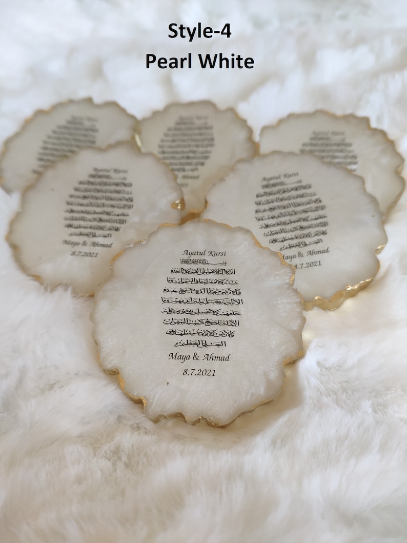 May include: White ceramic coaster with gold trim and Arabic calligraphy. The coaster features the text "Ayatul Kursi" and the names "Maya & Ahmad" with the date "8.7.2021".