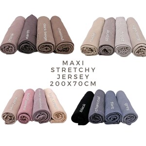 May include: A set of 12 maxi stretchy jersey scarves in various colors, including light beige, frost, grey, flint, nude, stone, chestnut, dark beige, mink, earth, lush cream, dusky lavender, skin pink, and sweet pink. The scarves are 200 cm by 70 cm.