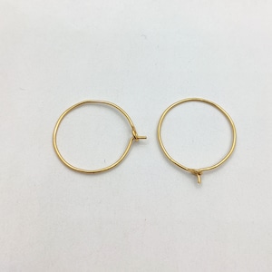 May include: A pair of gold hoop earrings with a simple, classic design.