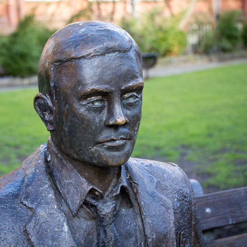 Puede incluir: Un busto de bronce de un hombre con una expresi&oacute;n seria. La escultura est&aacute; desgastada y muestra signos de la edad.