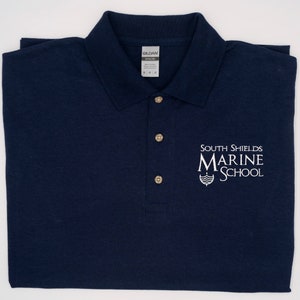 May include: A navy blue polo shirt with a white embroidered logo that says "South Shields Marine School".