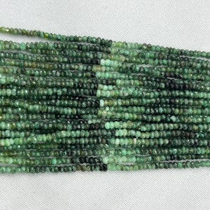 May include: A strand of emerald green gemstone beads. The beads are small and round, and they have a slightly faceted appearance. The beads are strung on a clear thread.