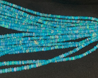 May include: A strand of light blue opal beads. The beads are small and round, and they have a slight iridescent sheen.