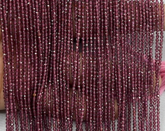 May include: Strands of faceted, deep burgundy beads. The beads are strung together, creating a curtain-like effect. The beads have a sparkling, reflective quality, suggesting they are made of a gemstone or crystal. The overall effect is elegant and luxurious.